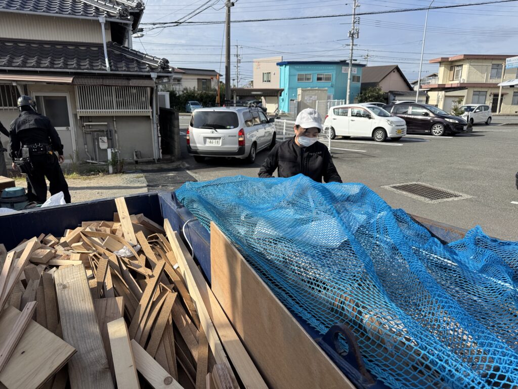 現場のゴミ箱に台風対策のネットをかける様子